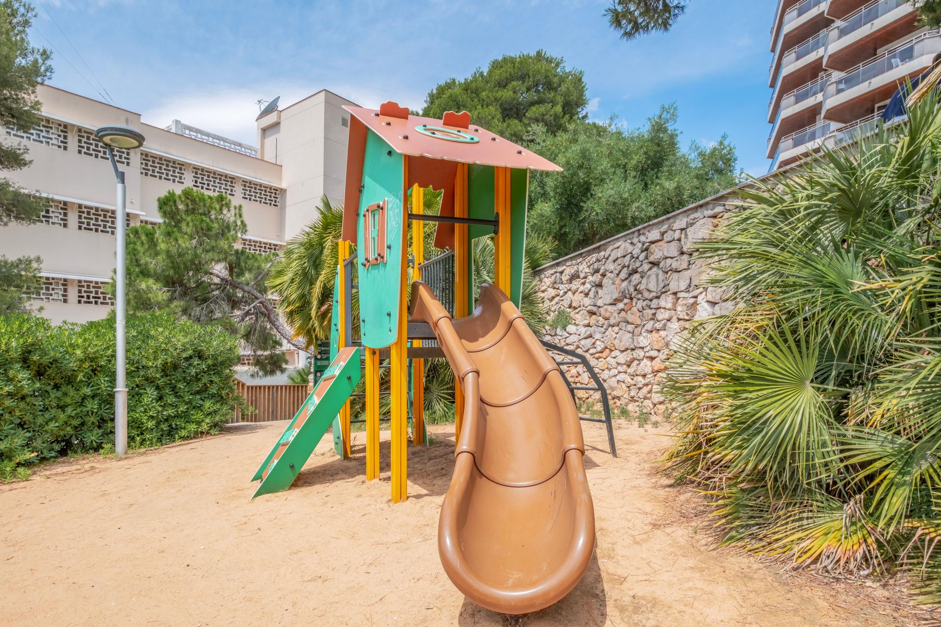 Colorful playground with slide, swings and other play equipment installed in a public park. Colorful playground for children in public park.